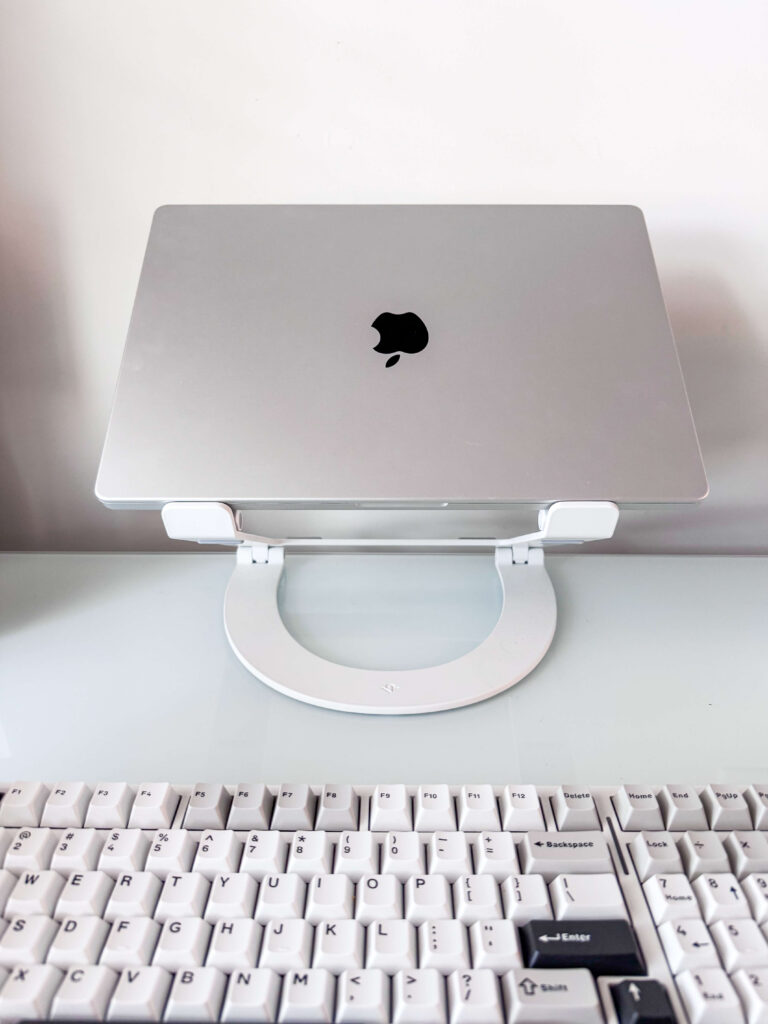 Macbook Pro 16 inch on a stand with a keyboard for photo editing on lightroom and photoshop